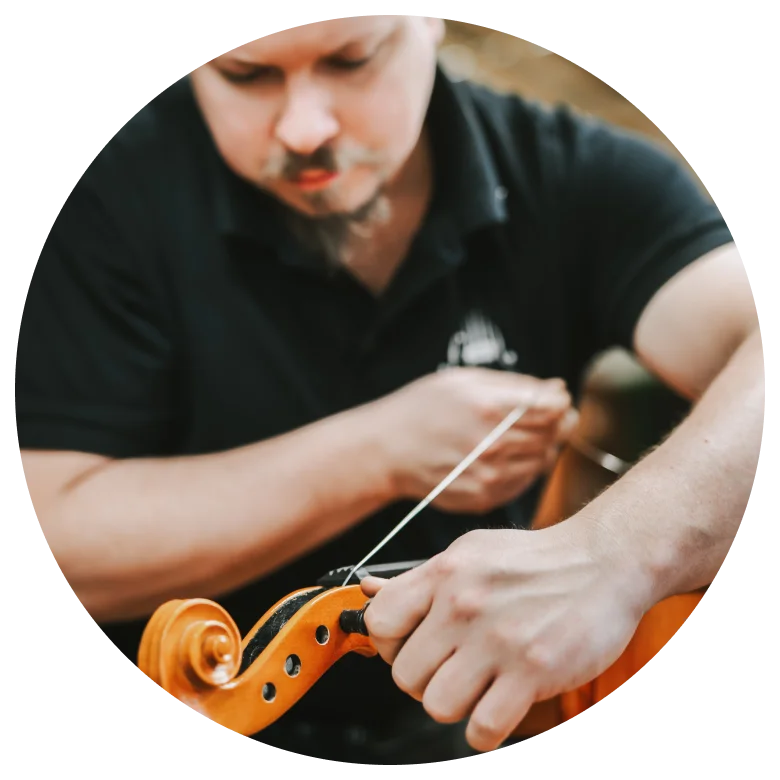 Lukas Neugebauer zieht Saiten in ein Instrument ein